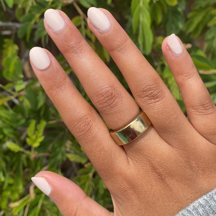 Hand with medium skin tone wearing It's Chilly! quick dry gel polish manicure in soft neutral beige outdoors