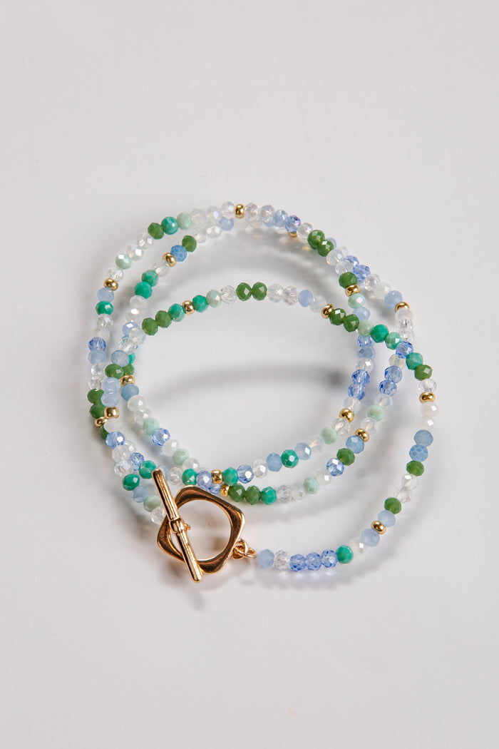 Multicolored beaded necklace with a gold clasp on a light gray background