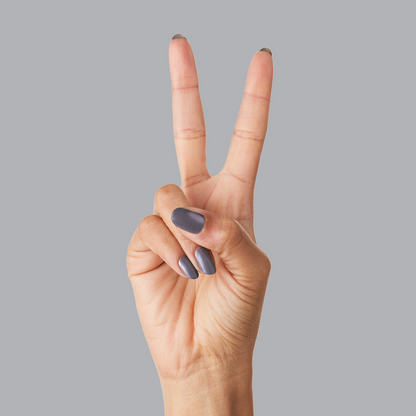 Hand showing nails painted in 100% CHANCE gunmetal blue polish for a sleek, long-lasting mani finish