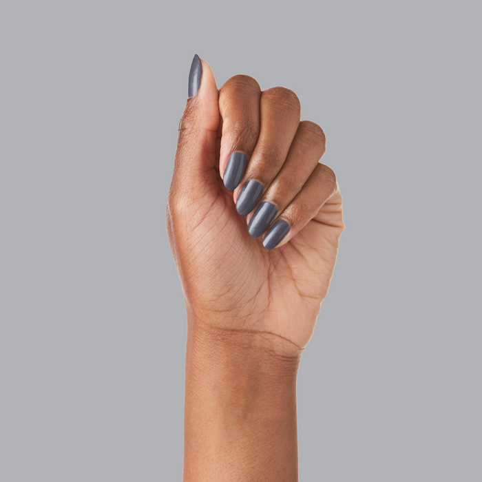 Hand with nails polished in 100% CHANCE gunmetal blue for a smooth, long-lasting manicure finish