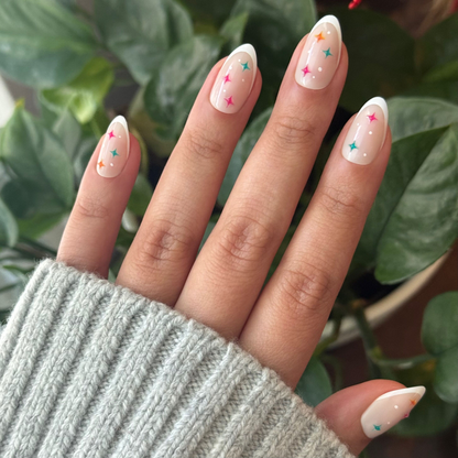 3D Gem French - Press-On | Medium | Almond nails with natural tips and colorful star accents for easy at-home manicure