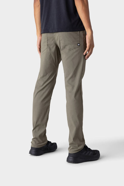 A person wears the 686 Mens Everywhere Merino-Lined Pant - Slim Fit in olive green with a black t-shirt and black sneakers, shown from the back against a white background‚Äîperfect for warmth and comfort in colder conditions.