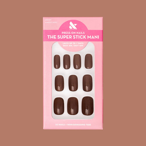 Americano | Short | Squoval - Tab Press-On showing a set of glossy coffee brown false nails in pink packaging on neutral background