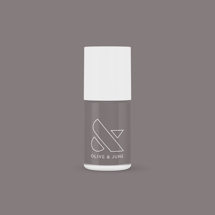 Olive and June AW nail polish bottle in warm grey shade on matching background for mani and manicure use