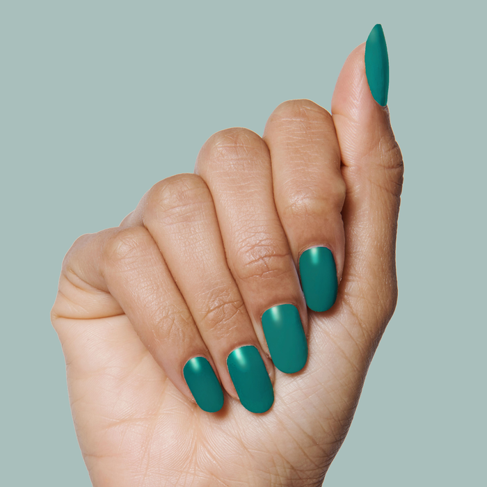 Hand with nails painted in deep teal shade Besties for a smooth, long-lasting manicure by Olive and June