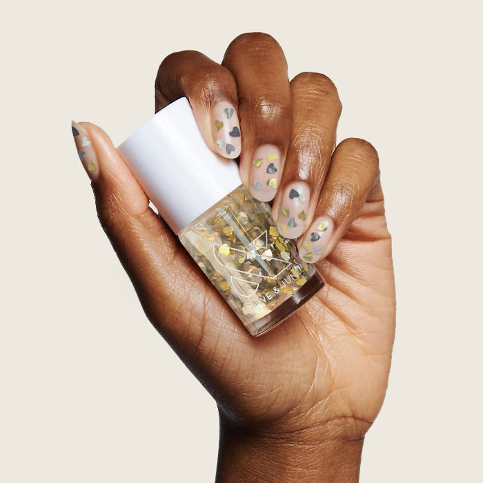 Hand with natural nails decorated with Biggest Fan glitter polish for a sparkling manicure by Olive and June