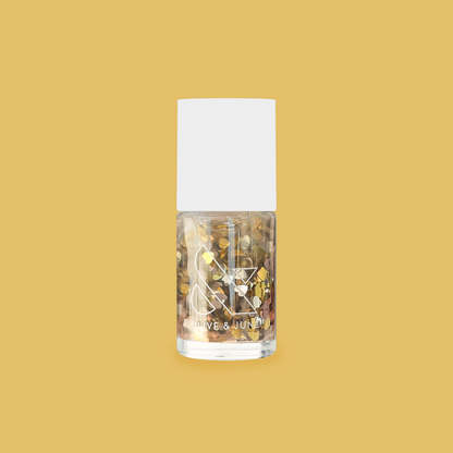 Clear nail polish bottle filled with silver and gold heart confetti glitter from Biggest Fan by Olive and June