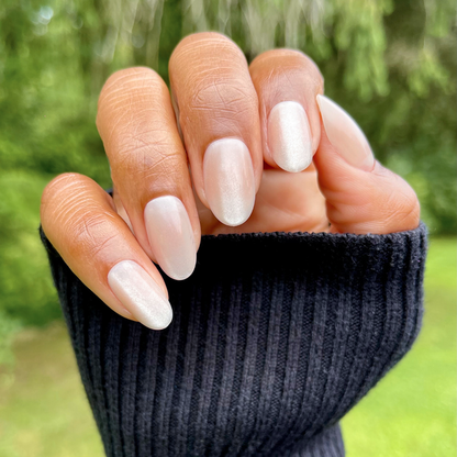 CDJ Velvet - Press-On | Medium | Oval nails in soft neutral shimmer with subtle velvet texture on hand outdoors