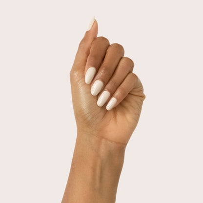 Hand showing smooth manicure with Chemistry light almond cream polish on soft pale neutral background