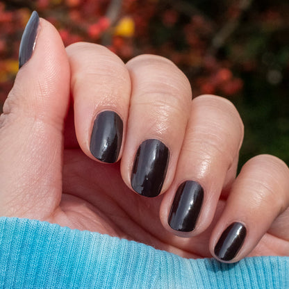Hand with nails coated in CN nail polish showcasing a smooth, long-lasting dark chocolate manicure idea
