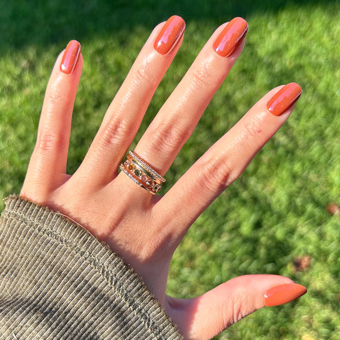 Cocoa Chrome - Press-On | Short | Round nails with shiny dark brown chrome finish on hand outdoors with rings