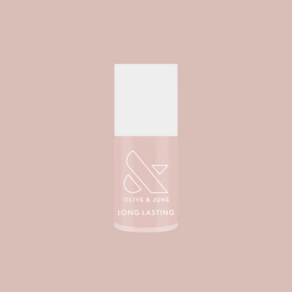 Bottle of Dream Job long-lasting nail polish in a soft milky sheer pink shade on a matching background