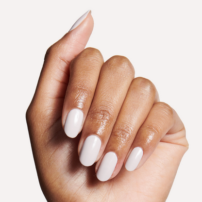 Hand with medium-length nails painted in ECC cool white grey polish for a sleek, long-lasting manicure look