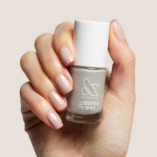 Elevator quick dry nail polish bottle held by hand with iridescent milky grey manicure nails