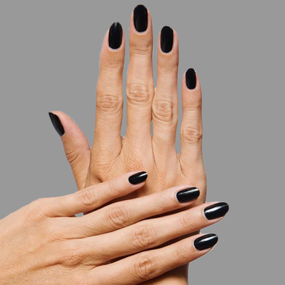 Hands with nails coated in rich black E+M nail polish by Olive and June showing a polished mani look