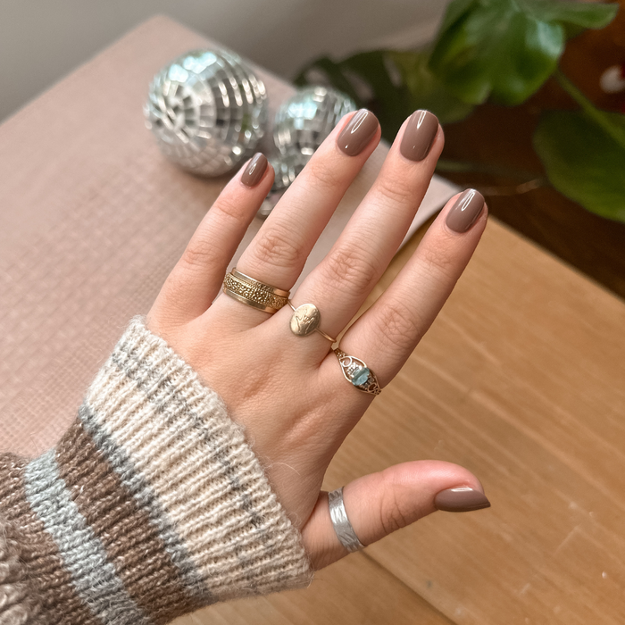 Fawn | Extra Short | Squoval - Tab Press-On showing short neutral brown false nails on hand with gold rings indoors