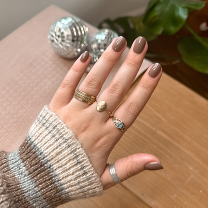 Fawn | Extra Short | Squoval - Tab Press-On showing short neutral brown false nails on hand with gold rings indoors