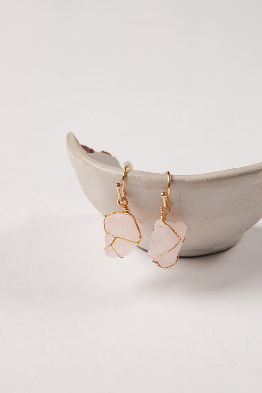 Rose quartz earrings with gold accents on a white background