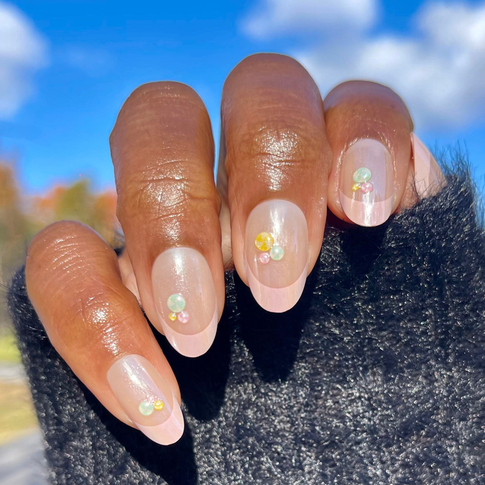 Frosted Candy Pink French - Press-On | Medium | Oval showing iridescent pink oval nails with 3D candy gumdrop accents outdoors