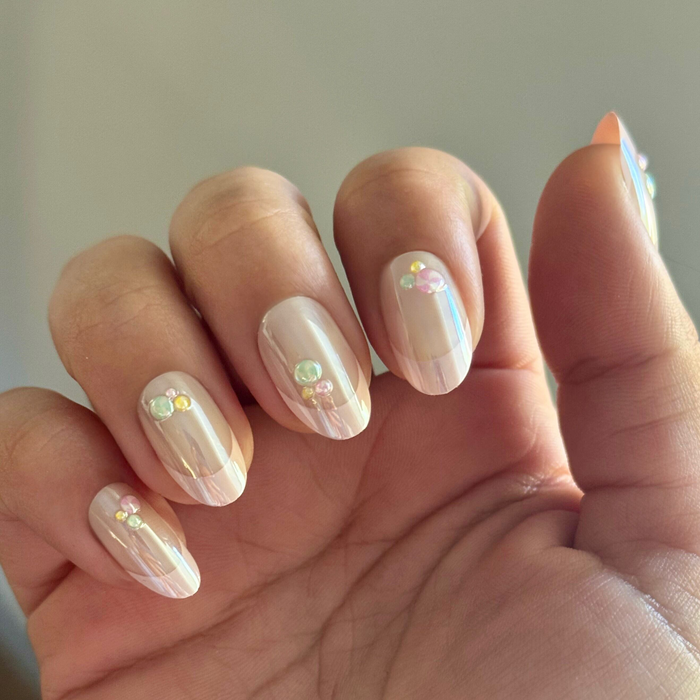 Frosted Candy Pink French - Press-On | Medium | Oval showing iridescent pink oval nails with 3D candy accents on natural hand