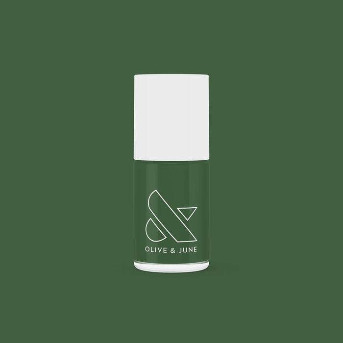 Bottle of Geometry nail polish in classic hunter green with Olive and June logo on a solid green background