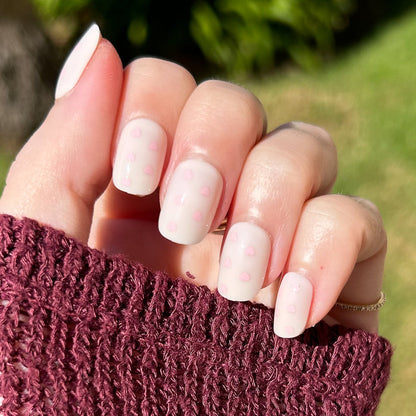 Heart Shower | Extra Short | Squoval - Tab Press-On neutral toned nails with tiny soft pink hearts worn with burgundy sweater outdoors