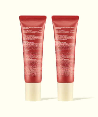 Two red tubes of Sun Bum Tinted Lip Duos standing side by side with white caps showing product directions.