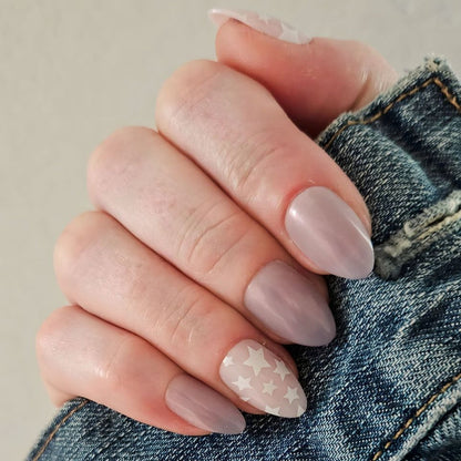 Hand with Mermaid Stars - Press-On | Medium | Almond nails featuring soft neutral tones and white star accents on one nail