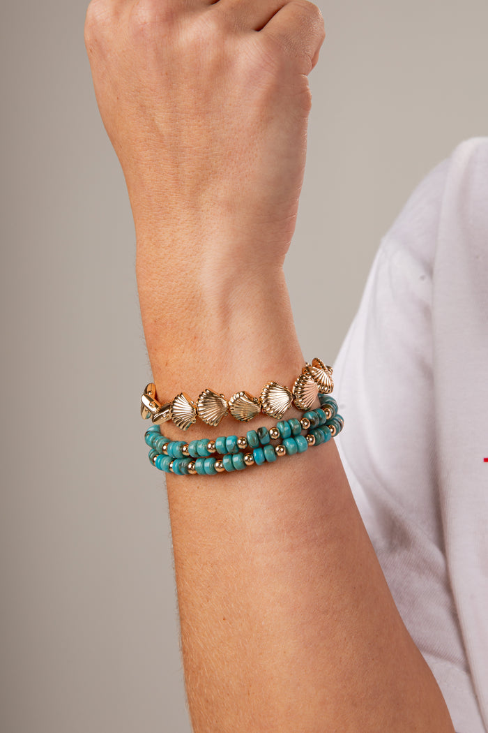 Close-up of a wrist wearing two bracelets with a neutral background