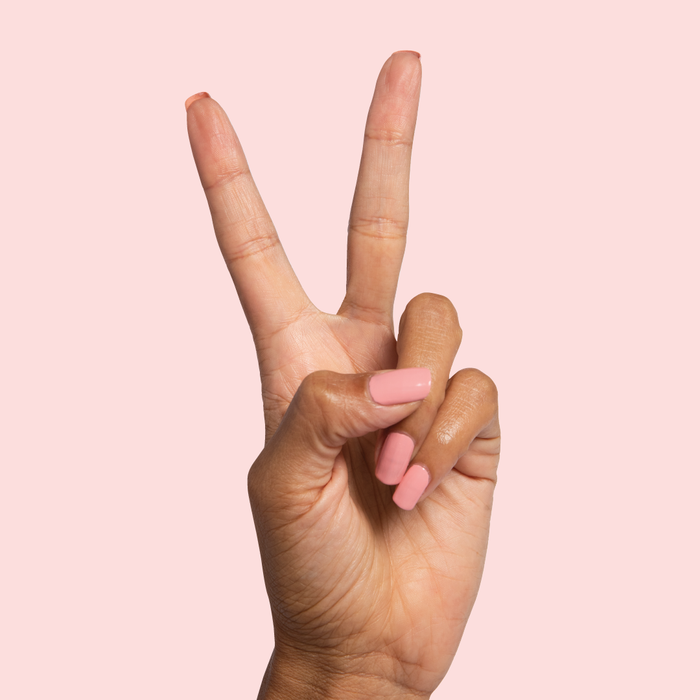 Hand with nails painted in Nuance medium bubblegum pink polish showing a smooth at-home manicure look