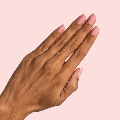 Hand with neatly shaped nails coated in Nuance medium bubblegum pink polish for a clean at-home manicure look