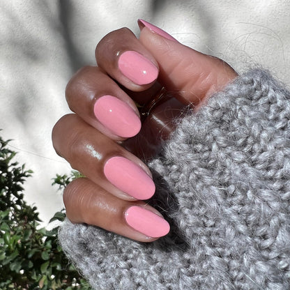 Hand with rounded nails painted in Nuance medium bubblegum pink for a fresh and polished at-home manicure look