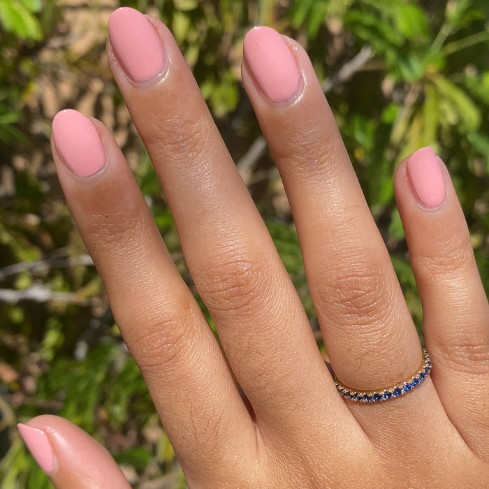 Hand with nails coated in Nuance medium bubblegum pink polish for a smooth and natural at home manicure look