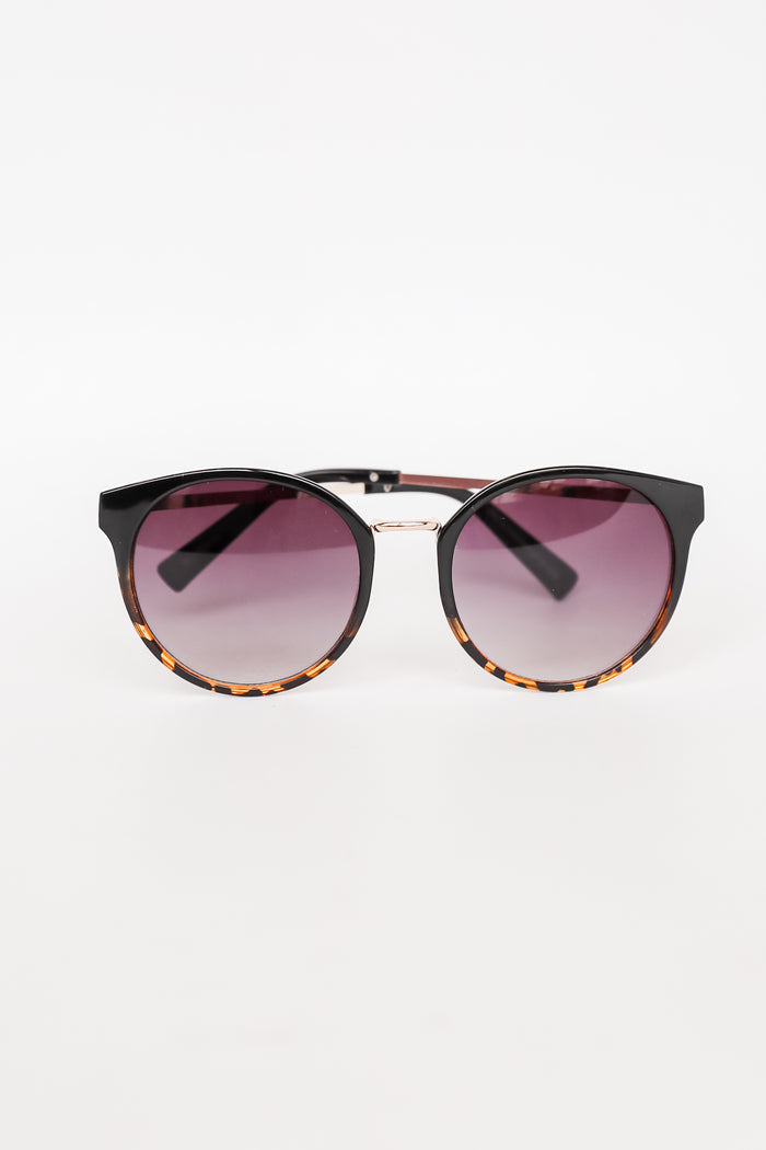 Sunglasses with tortoiseshell frame and gradient purple lenses on a white background
