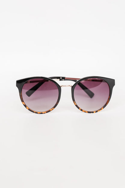 Sunglasses with tortoiseshell frame and gradient purple lenses on a white background