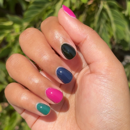 On the Town manicure showing vibrant green, pink, navy, and black quick dry polish on natural nails