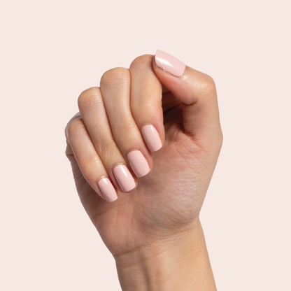 Hand displaying nails painted in Pointe ballerina pink polish for a clean, elegant at-home manicure look