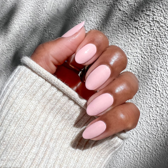 Hand with nails painted in Pointe soft pink polish for a smooth, elegant at-home manicure and pedicure look