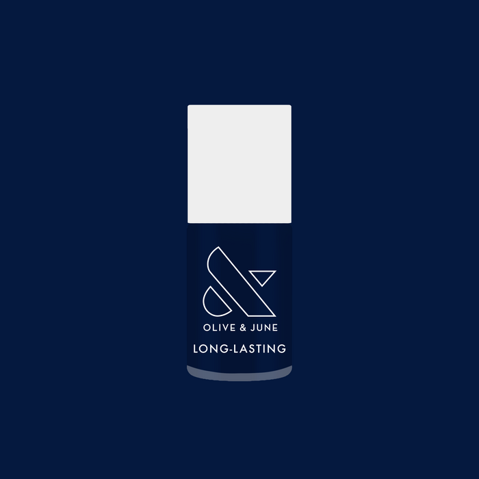 Bottle of Power Suit long-lasting nail polish in deep navy blue against matching background