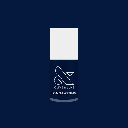 Bottle of Power Suit long-lasting nail polish in deep navy blue against matching background