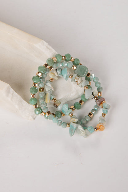 Set of three beaded bracelets with gold accents on a light background