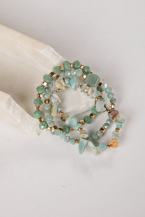 Set of three beaded bracelets with gold accents on a light background