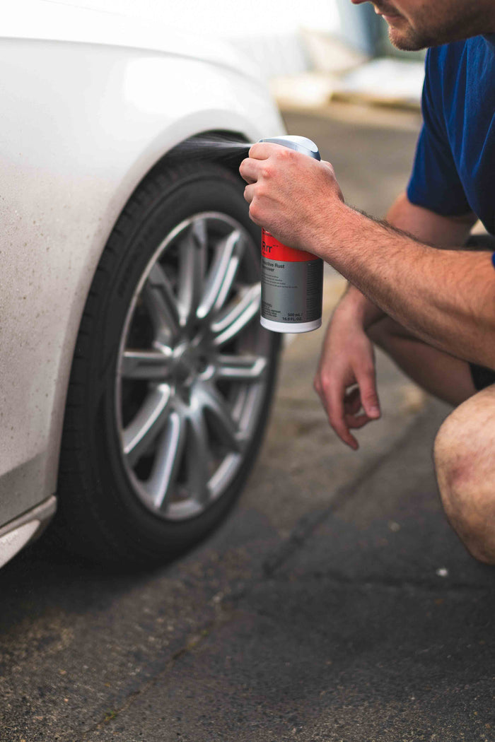 Person spraying KochChemie Reactive Rust Remover on a car