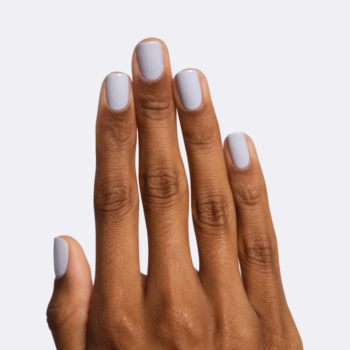 Hand with nails painted in icy pastel blue Rink polish for a smooth and quick dry at-home manicure look