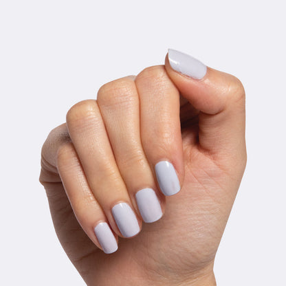 Hand with nails painted in icy pastel blue Rink quick dry polish for a smooth and fresh at-home mani look
