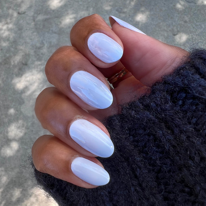Hand with nails painted in icy pastel blue Rink polish showing a smooth, glossy quick dry mani at home