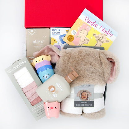 A baby gift hamper set including a plush hooded towel with bunny ears, organic hair and body wash, bamboo towelling washers, eco stack and pour animal cups, and a board book, all presented in a red box. Price: 149