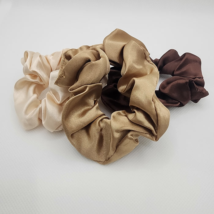 A set of satin scrunchies in various colors including black, gray, brown, beige, and pink, displayed on a cylindrical object.