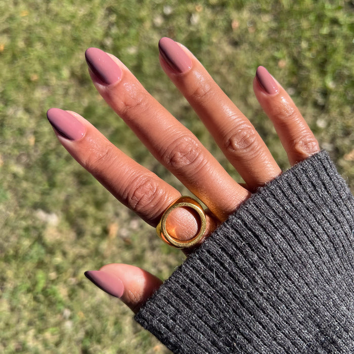 Hand with warm skin tone wearing Shacket gel polish in warm rose neutral for a natural long-lasting manicure outdoors