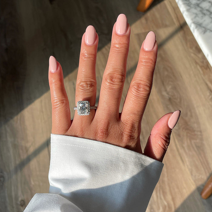 Hand showing glossy manicure in Study Hall vintage rose pink long-lasting polish with natural light on wooden floor background